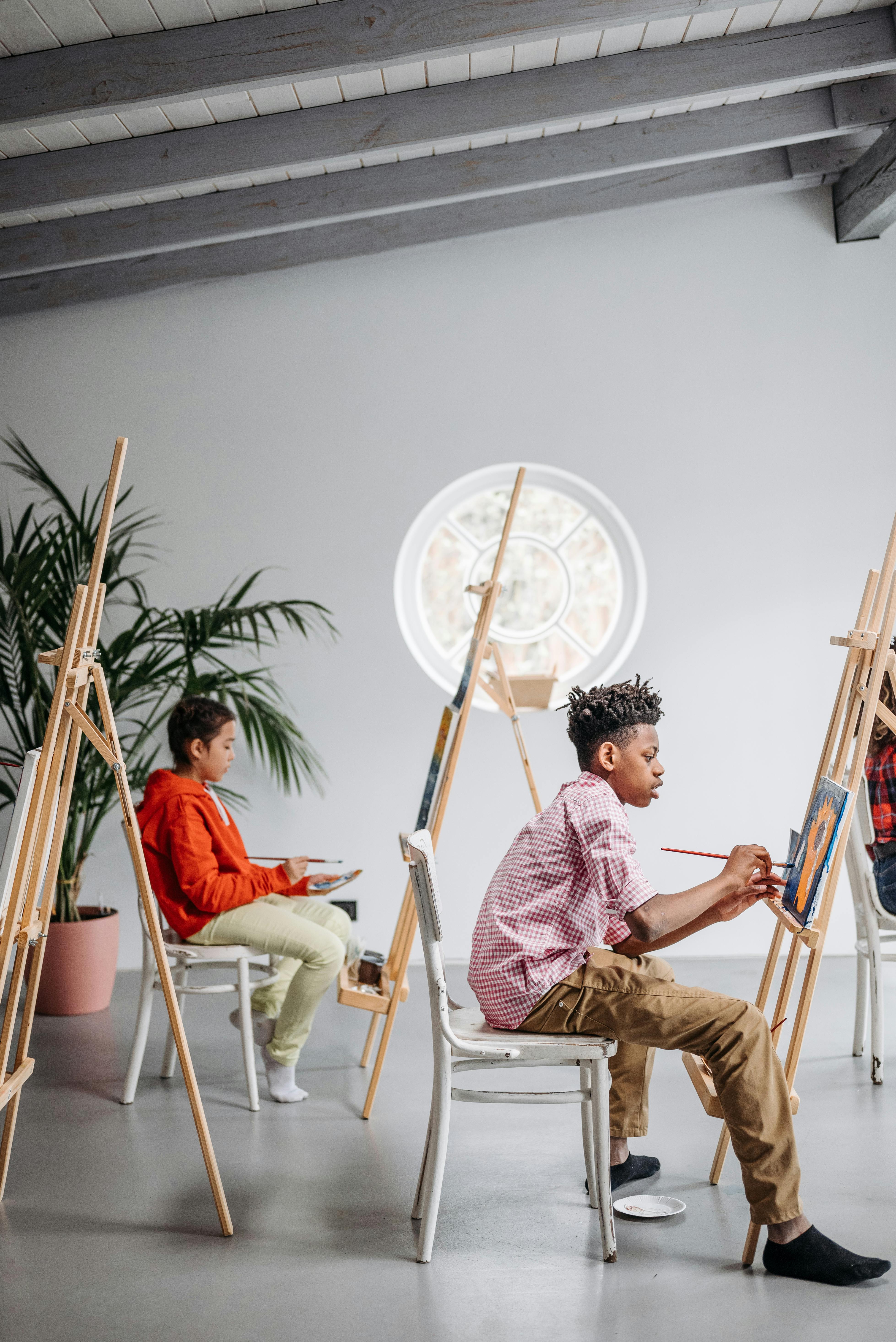 Adults participating in an art class with canvases and paint supplies.